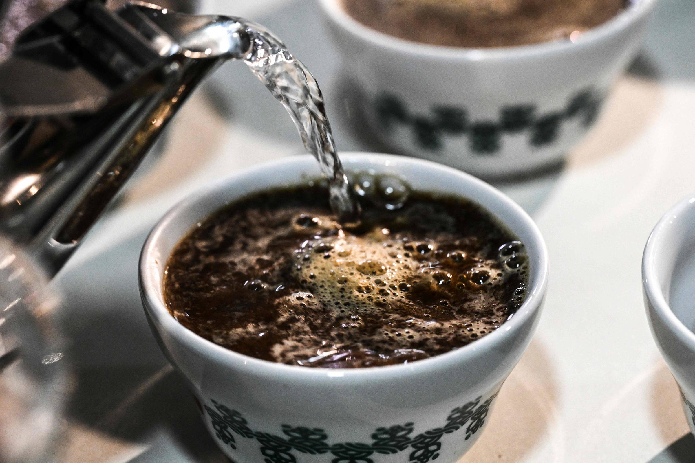 Água sendo despejada em xícara com pó de café