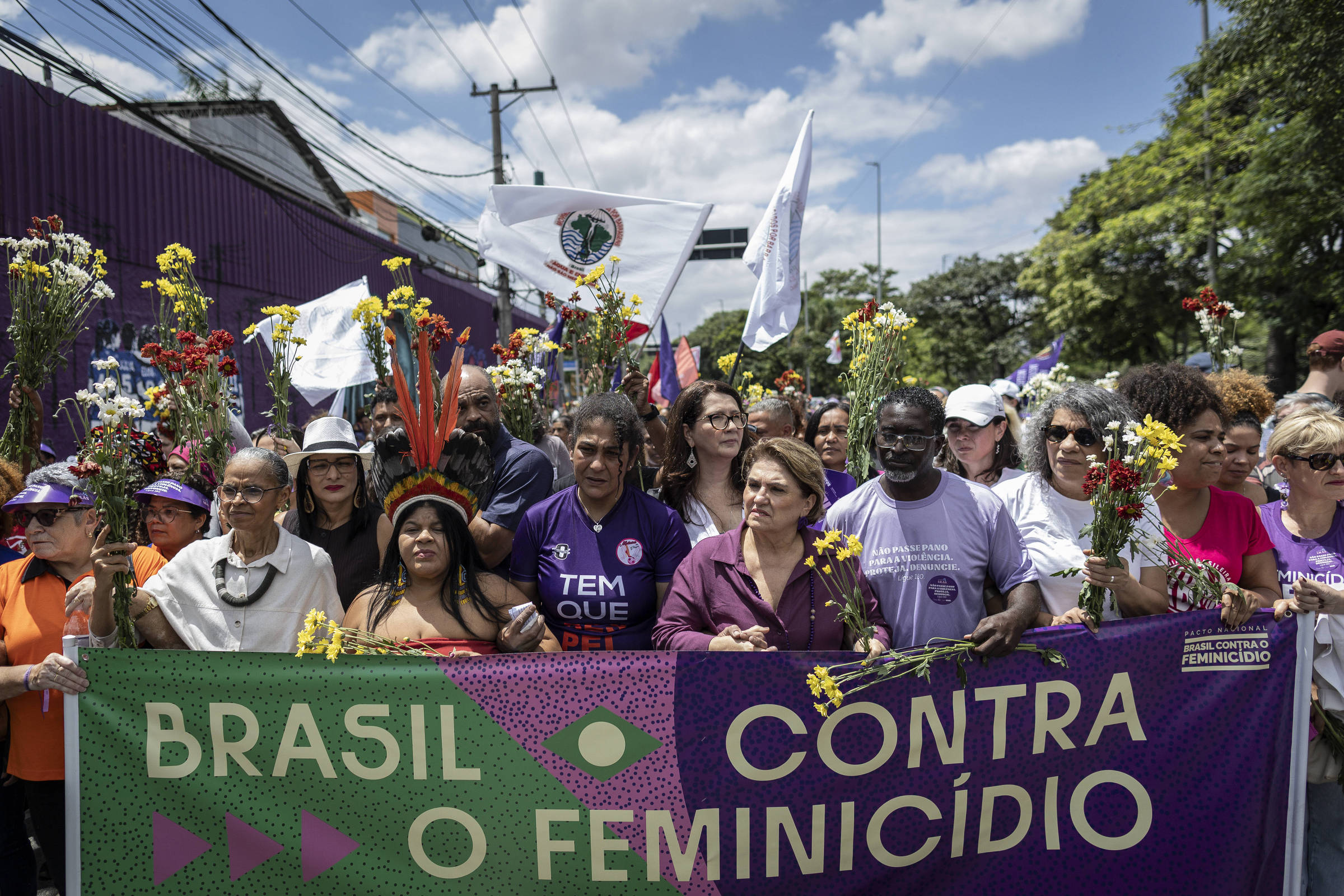 Grupo diverso de pessoas em manifestação segura faixa com os dizeres