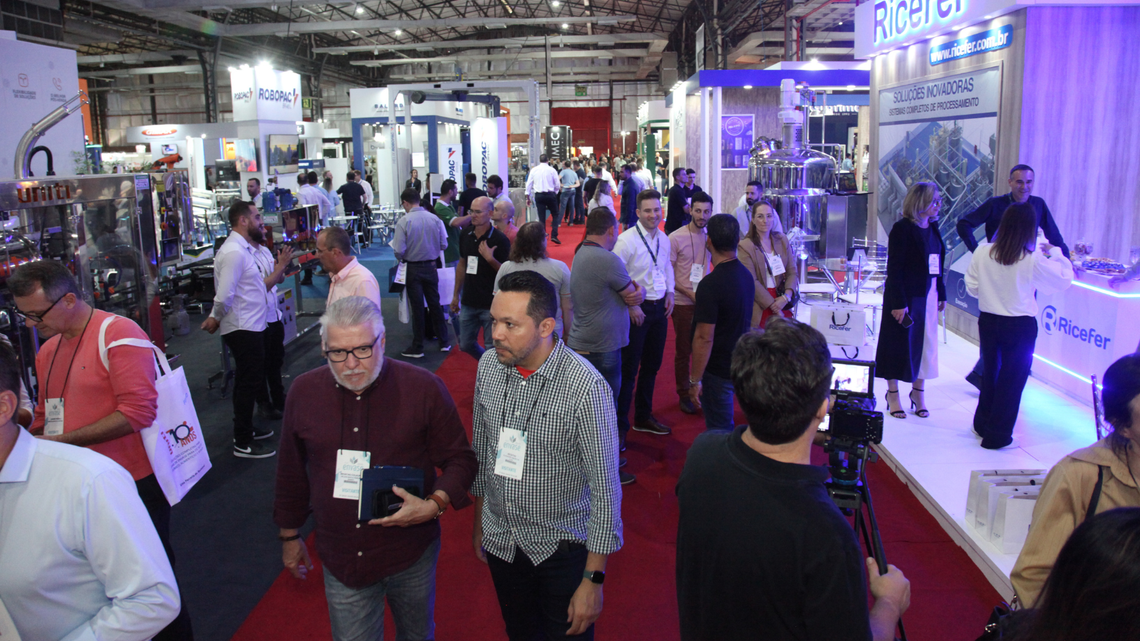 Visitantes circulam por estandes de tecnologia e máquinas industriais durante a Envase Brasil, feira do setor de envase e embalagens em Bento Gonçalves