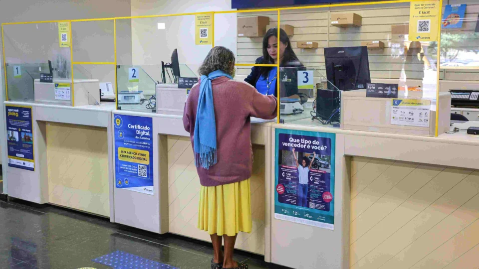 Cliente sendo atendido no balcão de uma agência dos Correios em Brasília