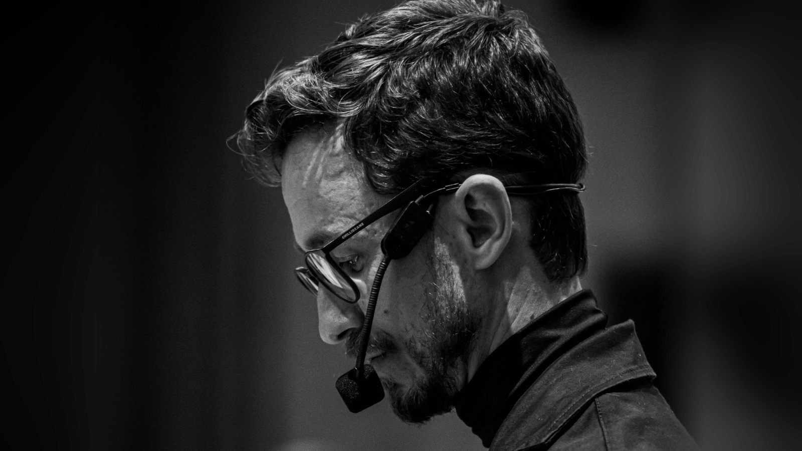 Raphael Galera, empresário e mentor de liderança, em retrato preto e branco durante apresentação com microfone.